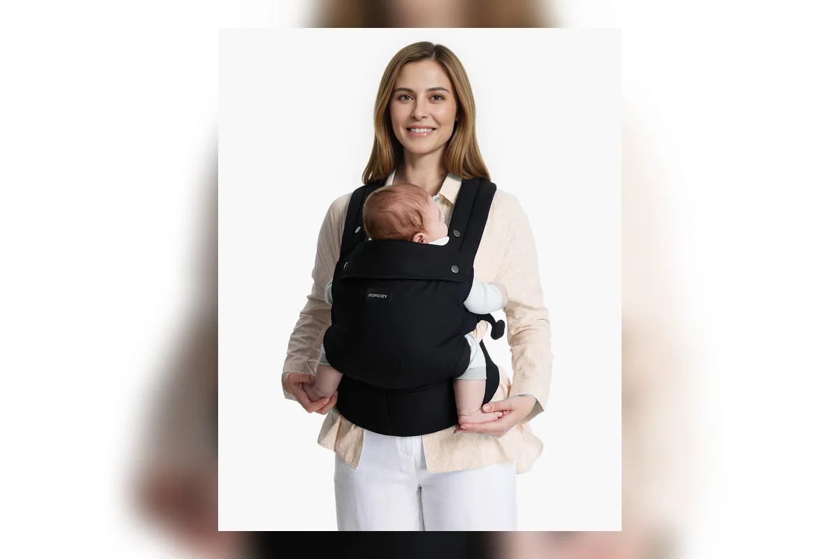 Mehrere ergonomische Babytragen nebeneinander auf einem hellen Tisch