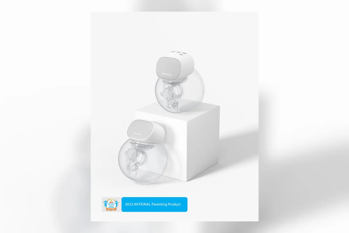 Flat-lay of a wearable breast pump, milk storage bags and nursing essentials on a cream background